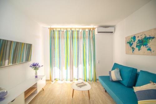 a living room with a blue couch and a table at Ona Internacional Apartments in Cambrils