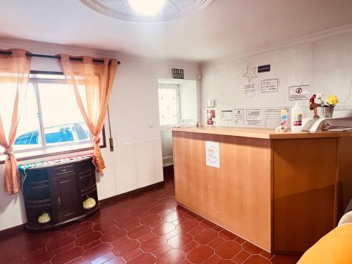 a kitchen with a counter top and a window at G & S - Hostel Vila do Conde in Gião