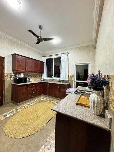 a large kitchen with wooden cabinets and a vase of flowers at 2BR & 3BR Sea View Condos in Dar es Salaam