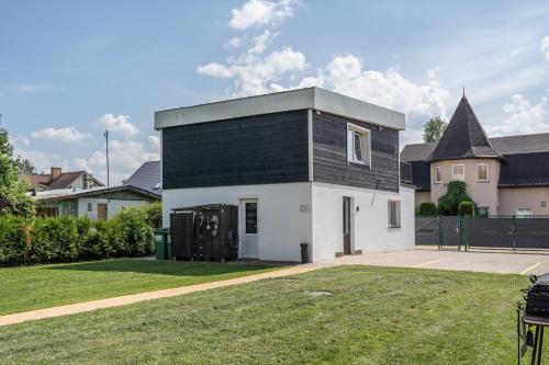 a black and white house with a yard at 4 Bedroom House with Playground, BBQ & Free Parking in Rīga