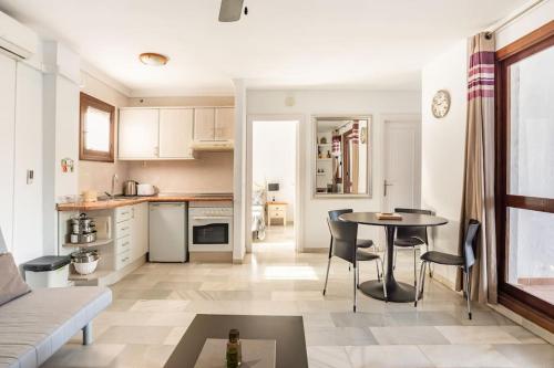 een keuken en een woonkamer met een tafel en stoelen bij Beautiful 2 bed apartment located at Pueblo Evita in Benalmádena