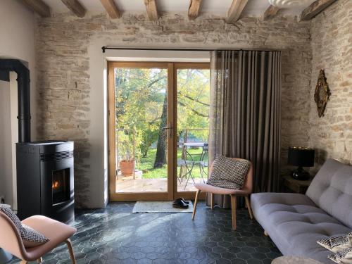een woonkamer met een bank en een open haard bij La Petite Maison in Auxey-Duresses
