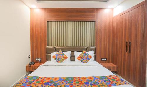 阿拉哈巴德FabHotel The Treenity House的带大床和木墙的卧室