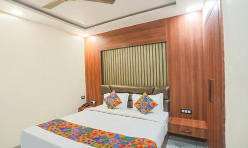 - une chambre avec un lit et une tête de lit en bois dans l'établissement FabHotel The Treenity House, à Allahābād