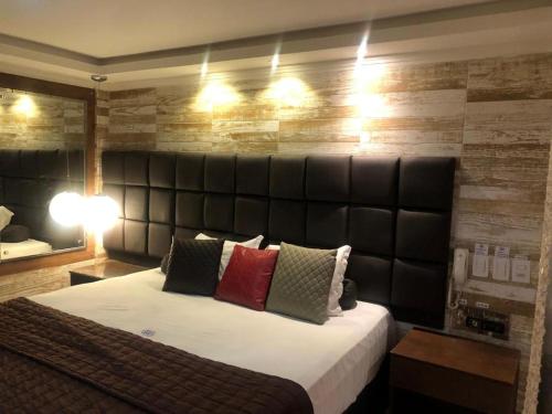 a bedroom with a large bed with a leather headboard at HOTEL BIGSTAR in Salvador