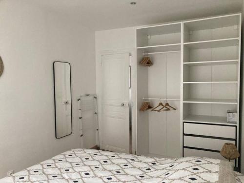 a bedroom with a bed and a mirror and shelves at Studio entier - Stade de France Paris in Saint-Denis
