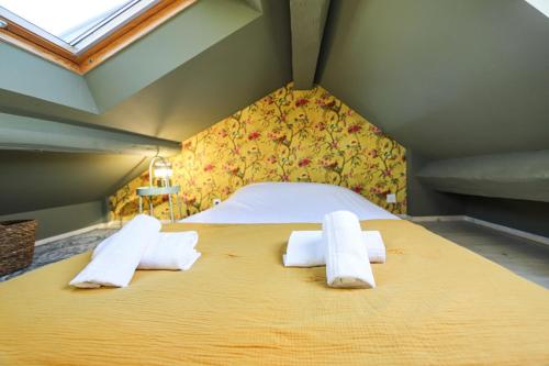 une chambre avec un grand lit avec des serviettes dessus dans l'établissement Le Fleuri Pretty triplex in the old town, à Annecy