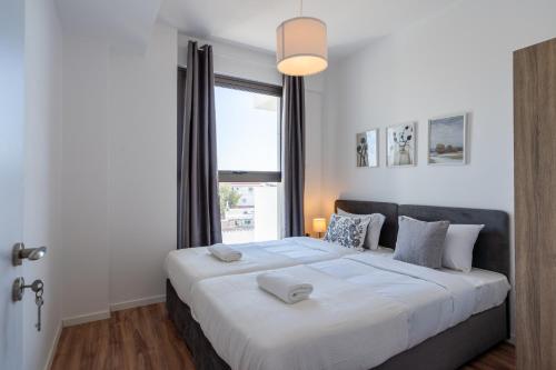 sypialnia z dużym łóżkiem i oknem w obiekcie Bianca 2-Bedroom Apartment in Larnaca w Larnace