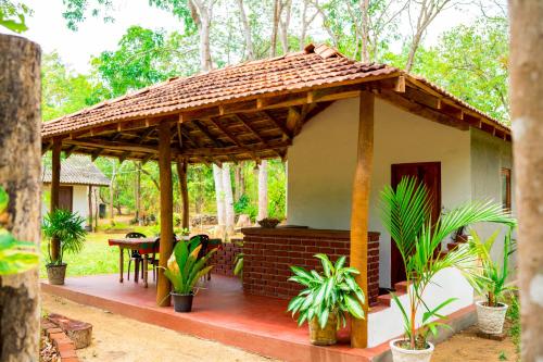 a small house with a roof on a patio at Wild Hut Habarana in Habarana