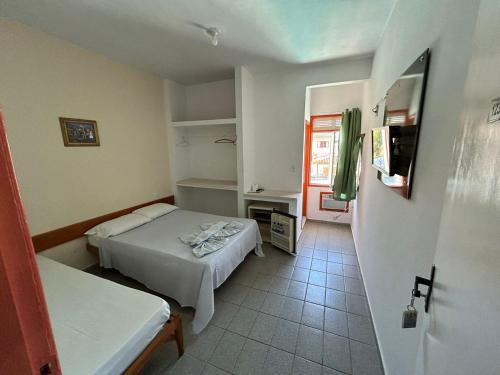 mały pokój z 2 łóżkami i kuchnią w obiekcie Pousada Itaúnas w mieście Conceição da Barra