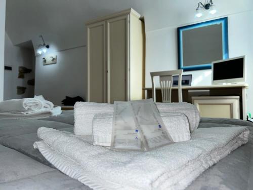 una pila de toallas sentadas encima de una cama en B&B Centro Storico, en Caltanissetta