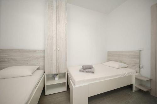 two beds in a small room with white walls at Apartment Stefanio in Vodice