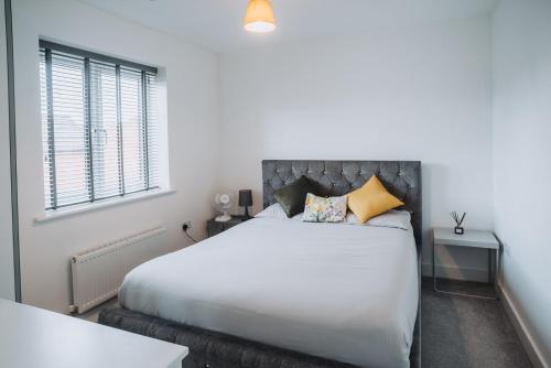 een slaapkamer met een groot wit bed en een raam bij Deluxe 2 Bed Flat in Patchway near Aztec West and Cribbs Causeway Bristol in Bristol
