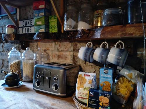 a kitchen counter with a toaster and some food at Large double room in Glasgow