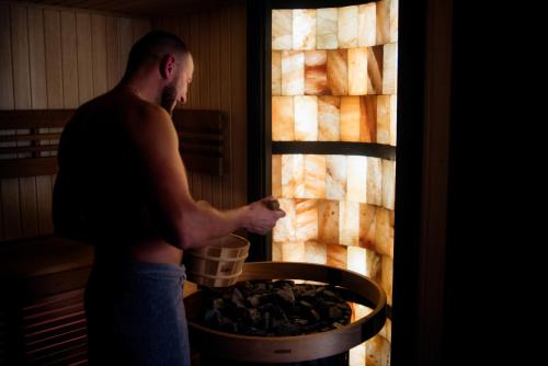 a man is putting food into an oven at Hotel Aquarius Restaurant Wellness Spa in Ciechocinek