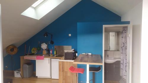 - une cuisine avec un mur bleu et un évier dans l'établissement Le Zen ( Calme et lumineux ), à Malzéville