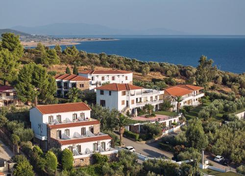 a cluster of houses on a hill next to the water at Glavas Inn Hotel in Gerakini