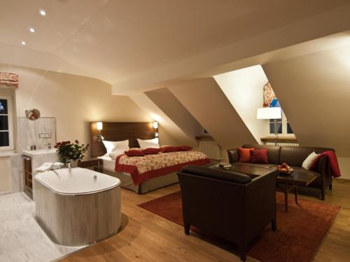 a bedroom with a bed and a living room at Pałac Pakoszów Schlosshotel Wernersdorf in Jelenia Góra