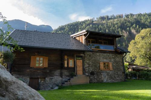 a log house with a mountain in the background at Chalet Schmelz Huette mit Sauna und Garten in Flattach