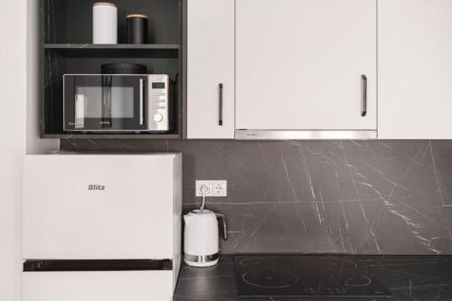 a kitchen with white cabinets and a black counter top at Apartment Stefanio in Vodice
