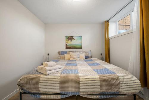 a bedroom with a bed with towels on it at Private Town Home with Free Banff Access, Netflix, King Bed, Fully Equipped Kitchen, Sleeps 4 in Calgary
