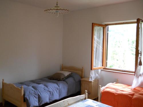 a bedroom with two beds and a window at Baita Figliezzi in Castello Tesino