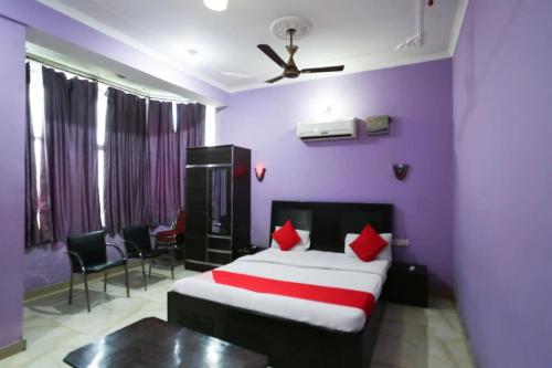 1 dormitorio con cama y pared púrpura en OYO Hotel Alfa, en Amb