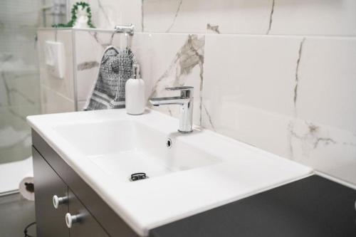 a white bathroom sink with a soap dispenser on it at Apartment Stefanio in Vodice