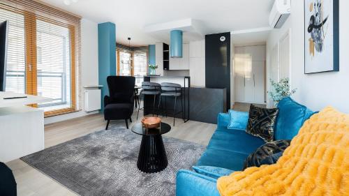 un soggiorno con divano blu e tavolo di Apartament Sun & Snow Premium w Novum a Cracovia