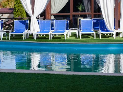 a group of blue chairs next to a swimming pool at Номер Стандарт 