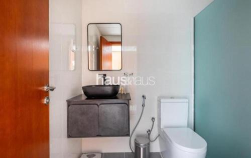 a bathroom with a sink and a toilet and a mirror at Phineek Studio Apartment The Green Al Alka in Dubai