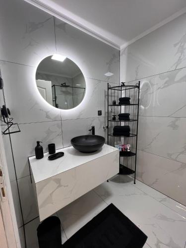 un baño con lavabo y espejo en Lux Apartman Inđija, en Inđija