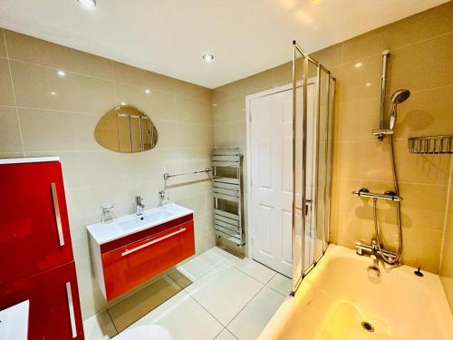 a bathroom with a tub and a sink and a shower at Cosy 3 Bed House - Reading Cent. Free Parking in Reading