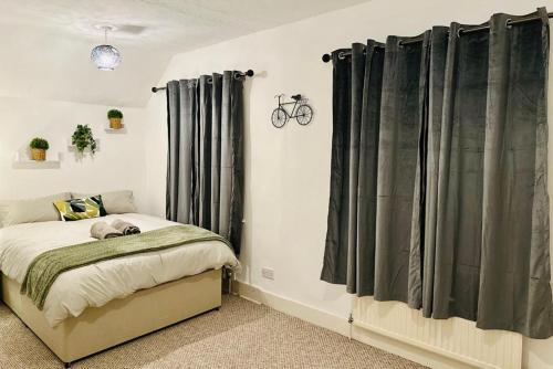 um quarto com uma cama com cortinas cinzentas em Cosy 3 Bed House - Reading Cent. Free Parking em Reading