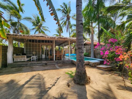 a resort with a swimming pool and palm trees at Bamboo Lodge in Gili Trawangan