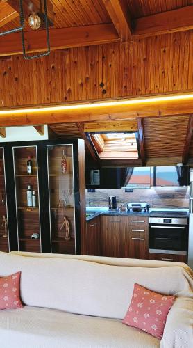 a living room with a couch and a kitchen at Attic in Nea Moudania