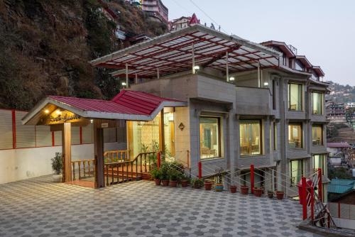 a house with a red roof on a street at Rock Castle By DLS Hotels in Shimla
