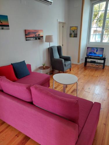 a living room with a pink couch and a table at Lightoasis Oeiras 1 in Oeiras