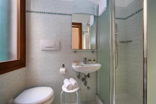 a bathroom with a toilet and a sink and a shower at Hotel Guerrini in Venice