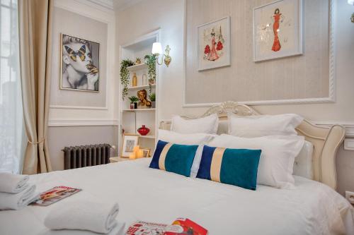 - une chambre dotée d'un lit blanc avec des oreillers bleus et blancs dans l'établissement Charmant 150m2 5CH Romantic - Centre Ville - Clim, à Paris