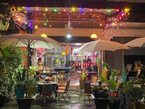 twee parasols in een restaurant met tafels en stoelen bij Chai Ben guesthouse in Jomtien Beach