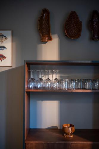a shelf with glasses and vases on a wall at Hôtel du DOMAINE SAINT LOUP in Michelbach