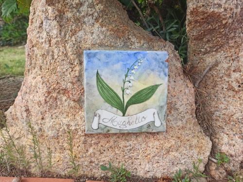 a painting of a flower in a pot on a tree at CASA MUGHETTO - seafront, private sea access and swimming pool in La Maddalena