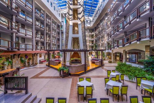 an emptyrium of a building with tables and chairs at MPM Hotel Guinness in Bansko