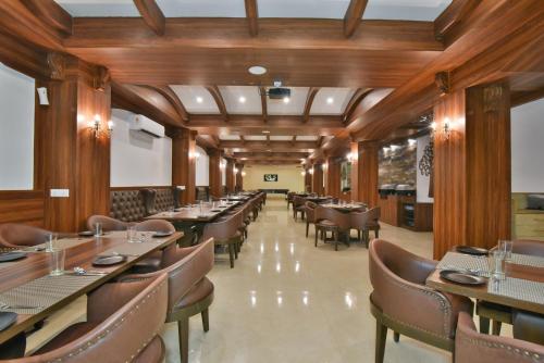 a dining room with wooden walls and tables and chairs at Hotel Highland By DLS Hotels in Mussoorie