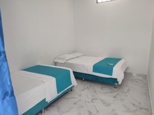 two beds in a room with white and blue at Proyecto MOONLIGHT in Villavieja