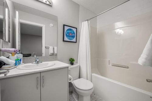 a bathroom with a toilet and a sink and a shower at Extra Large House with AC, Banff Access, Sleep 12, BBQ, 4 Bedrooms & 2 Sleeper Sofa Beds in Airdrie