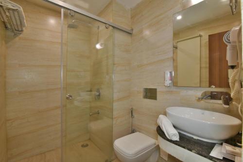 a bathroom with a shower and a sink and a toilet at Hotel Highland By DLS Hotels in Mussoorie