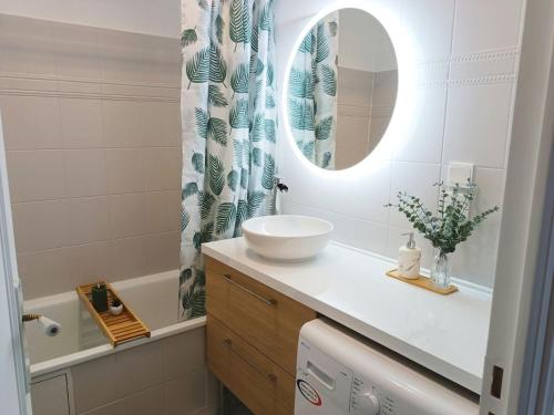 une salle de bains avec un lavabo et un miroir dans l'établissement Le 1A, Charmant Appartement au Cœur de la Ville, à Gérardmer