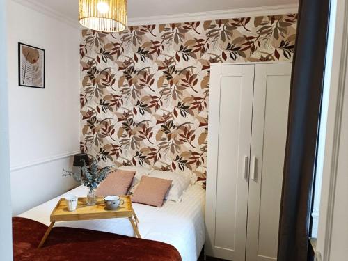 - une chambre avec un lit orné d'un mur fleuri dans l'établissement Le 1A, Charmant Appartement au Cœur de la Ville, à Gérardmer